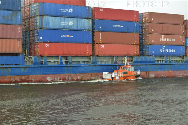 Pilot boat and container ship sailing in the Kiel Canal