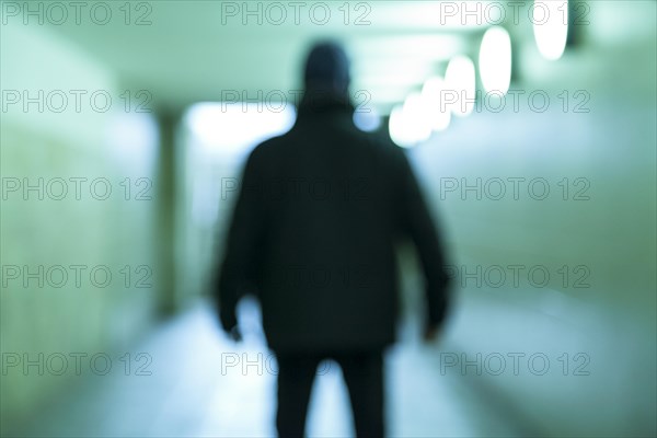 Blurred person standing in a tunnel
