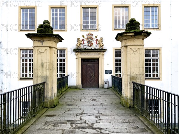 View over bridge from moat to entrance door of historic moated castle Burg Schloss Borbeck