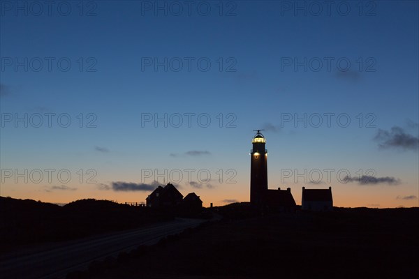 Eierland Lighthouse in the dunes silhouetted against sunset on the northernmost tip of the Dutch island of Texel