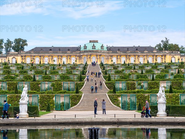 The water reflection of the Great Fountain and behind it Sanssouci Palace with the staircase and Sanssouci Park