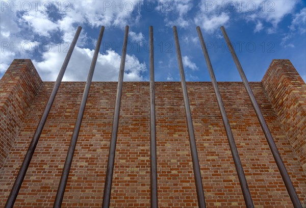 Rusty iron bars in front of brick wall