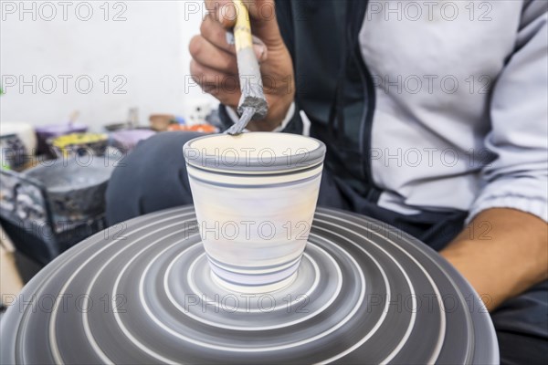 Craftsman painting and decorating ceramic products in pottery factory in Fez