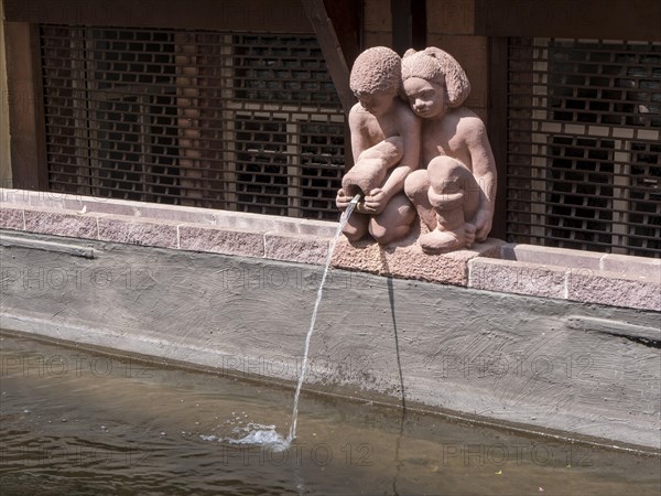 Small statues of a girl and a boy with a jug