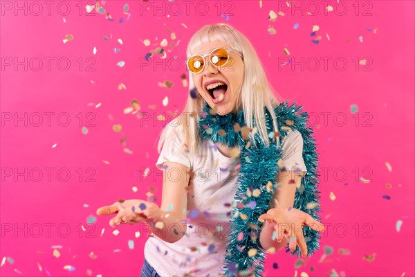 Smiling at a party throwing confetti in sunglasses