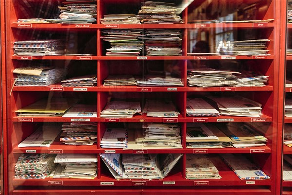 Red mailboxes with letters behind glass