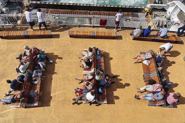 Passengers sitting on benches on deck