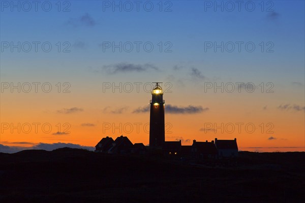 Eierland Lighthouse in the dunes silhouetted against sunset on the northernmost tip of the Dutch island of Texel