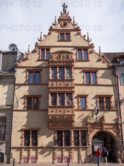 A reddish medieval building La Maison des Tetes in Rue des Tetes