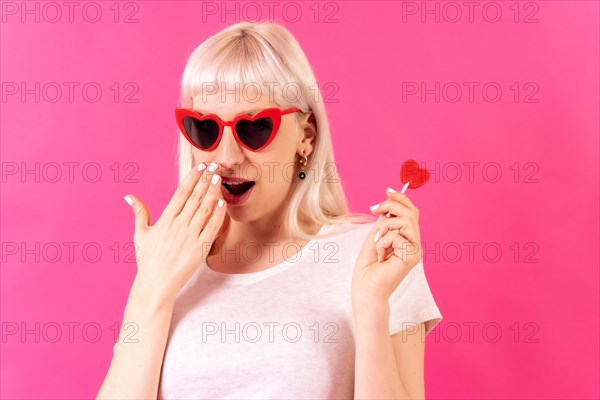 Blonde caucasian girl in studio on a pink background