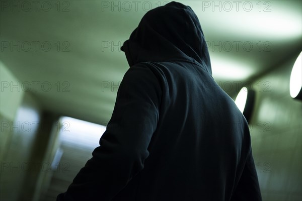 Man with hoodie in tunnel