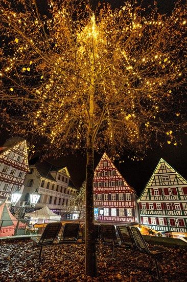 Illuminated tree at Christmas market at night