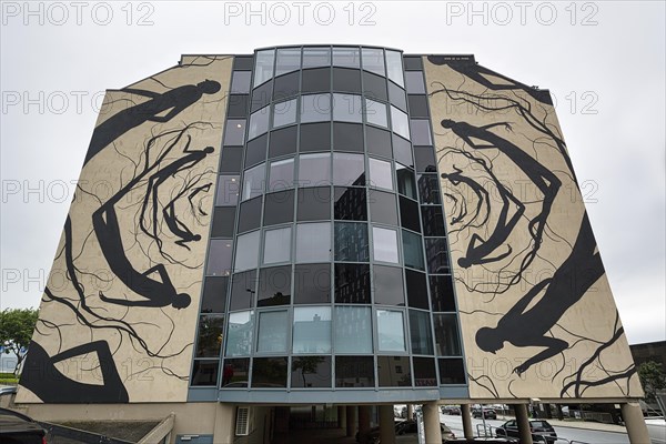 Mural with silhouettes of people and roots