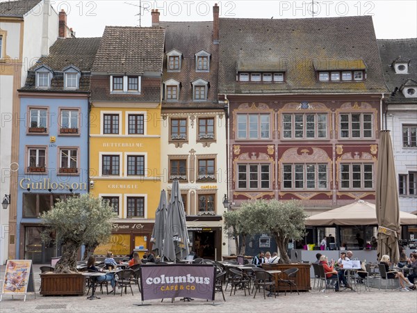 Medieval building with tables in the restaurant around the Place de la Reunion