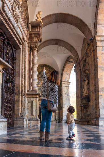 Mother and son at the door of the Sanctuary of Loyola pointing to sculptures