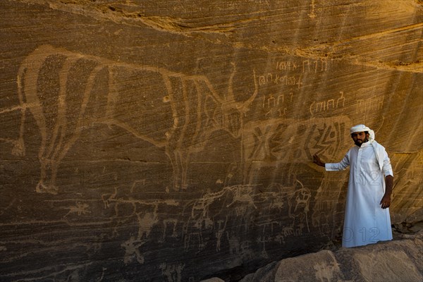 Man pointing at rock carvings