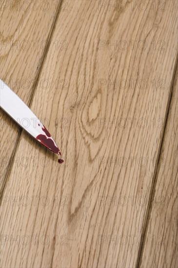 Bloodstained knife on a wooden floor