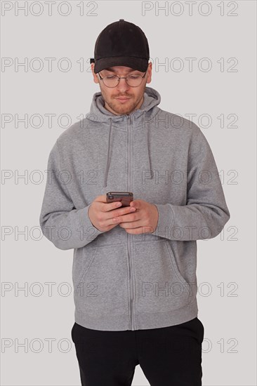 Fashionably sporty man typing on his mobile phone