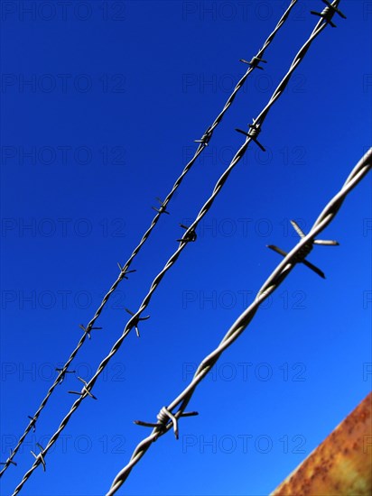 Barbed wire against a blue sky