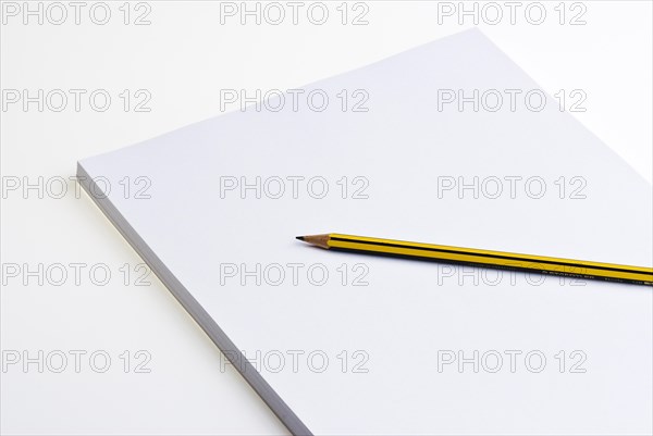 Blank pad of white paper with a pencil on a white background