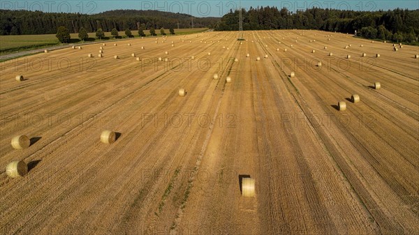 Aerial view of a harvested grain field with straw bales near Augsburg in Swabia