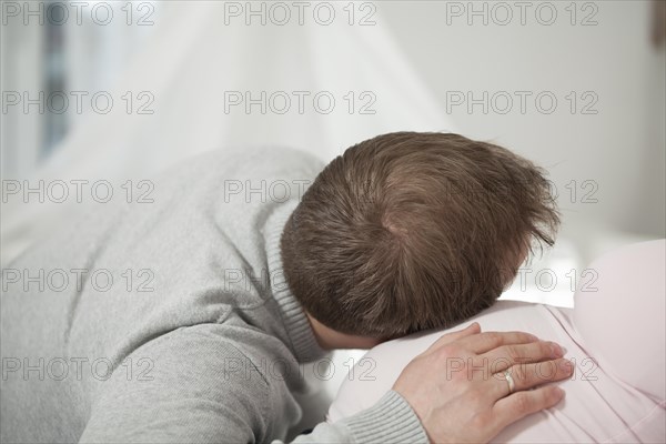 Man listening to the belly of a pregnant woman