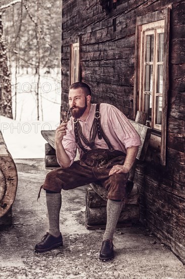 Bavarian man with lederhosen and pipe in hand