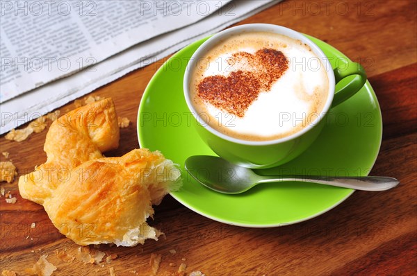 Capuccino dusted with cocoa powder in the shape of a heart