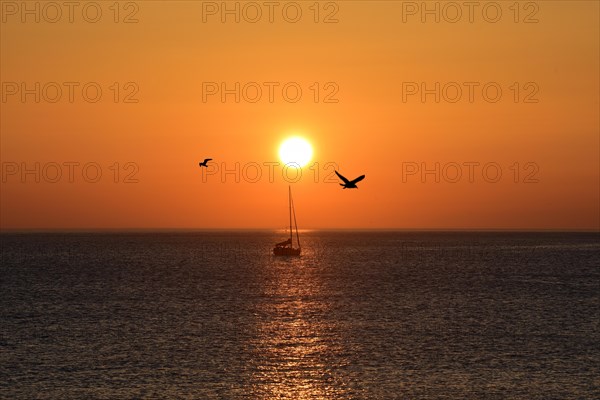 Sunset with sailboat on the Atlantic Ocean in Normandy