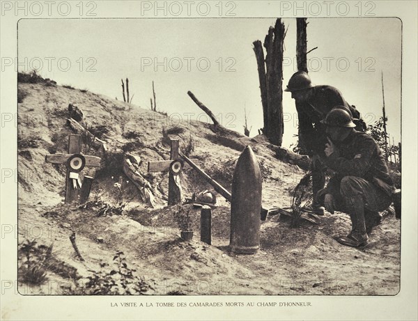 Soldiers visiting temporary graves decorated with artillery shell at battlefield in Flanders during First World War