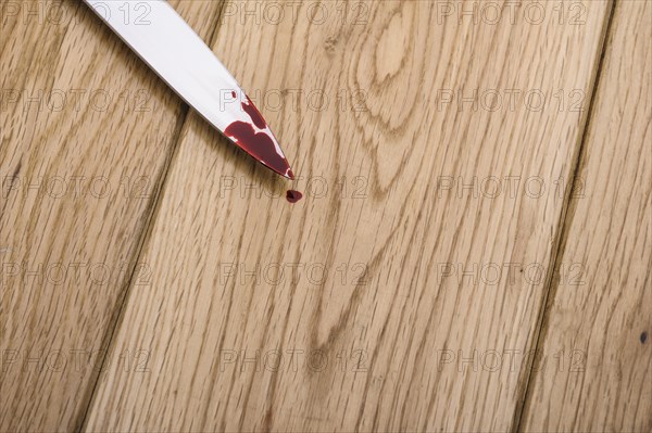 Bloodstained knife on a wooden floor