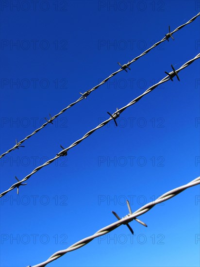 Barbed wire against a blue sky