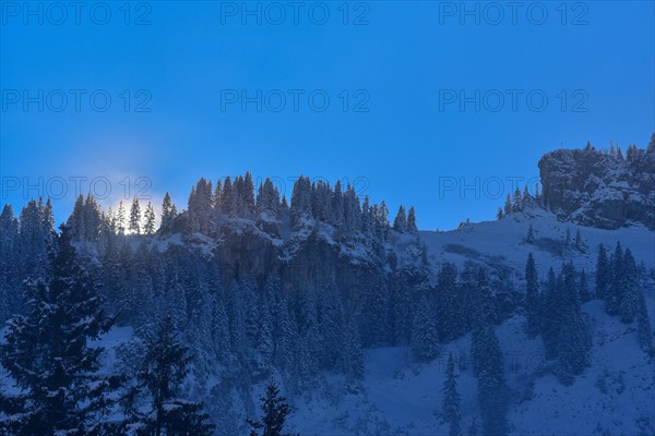 The sun breaks through the high fog at the Riedberg Pass near Obermaiselstein in Allgaeu