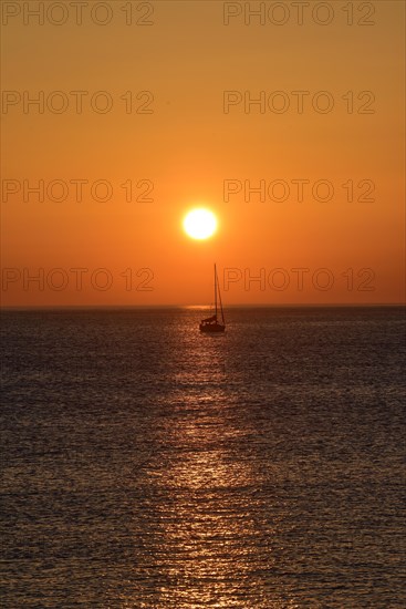 Sunset with sailboat on the Atlantic Ocean in Normandy