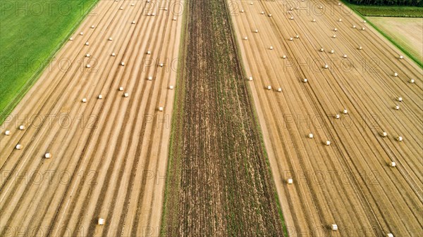 Aerial view of a harvested grain field with straw bales near Augsburg in Swabia