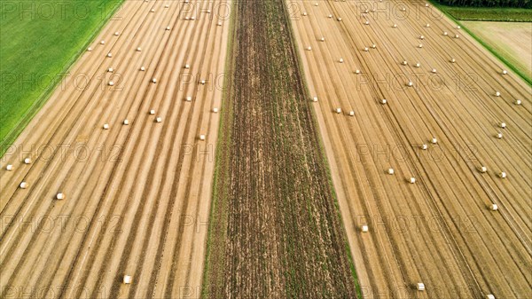 Aerial view of a harvested grain field with straw bales near Augsburg in Swabia