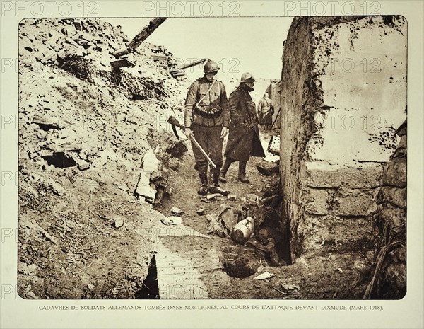 Belgian soldiers looking at dead German killed in action in trench at Diksmuide in Flanders during the First World War