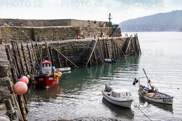 Fishing boats safely moored behind the protection of harbour wall