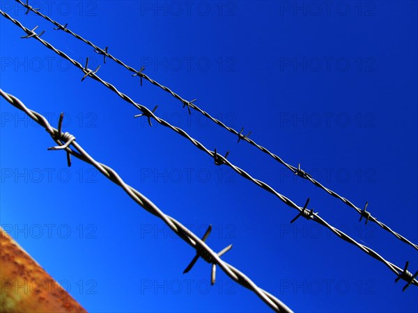 Barbed wire against a blue sky