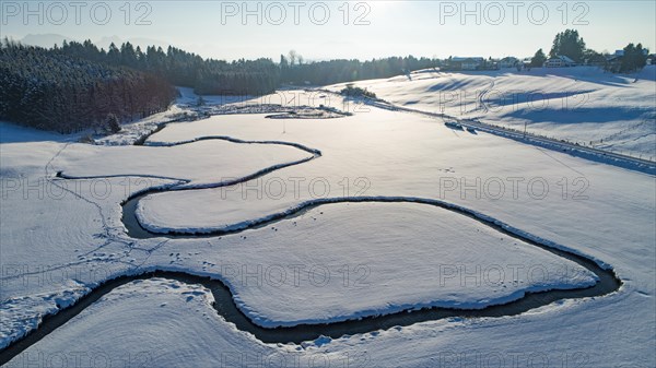 Winter landscape in Allgaeu with stream and railway line
