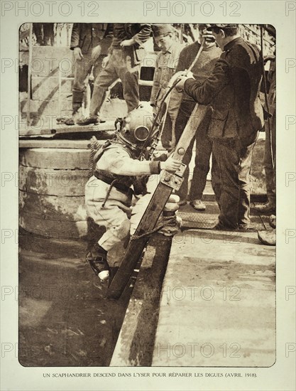 Diver wearing helmet descends ladder to repair the dikes along the river Yser