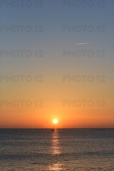 Sunset with sailboat on the Atlantic Ocean in Normandy