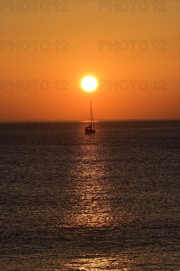 Sunset with sailboat on the Atlantic Ocean in Normandy