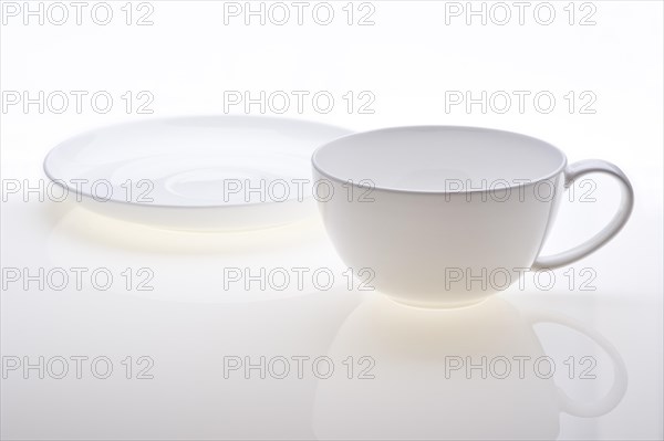 Cup and saucer standing separately on white background