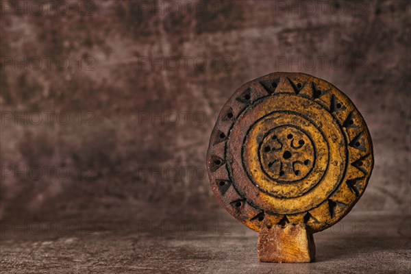 Close-up of a hand-carved and hand-painted stone disc