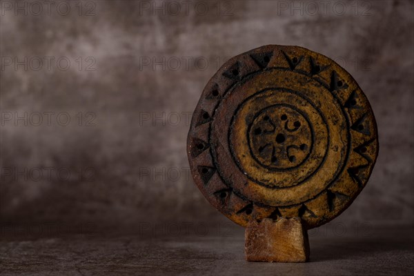 Close-up of a hand-carved and hand-painted stone disc