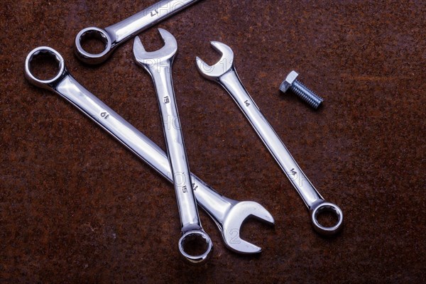 Combination open ended and ring spanners on a rusty sheet metal ground