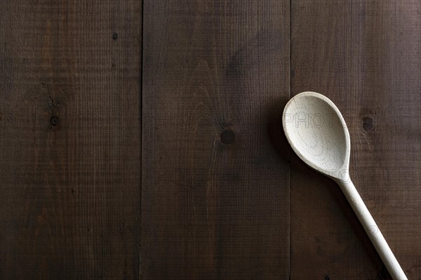 Traditional wooden spoon on a dark board background
