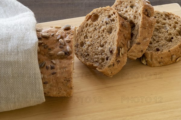 Sliced multi seeded baguette on a bread board