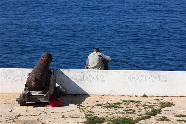 Cliff fishermen and historic cannon at the Fortaleza de Sagres